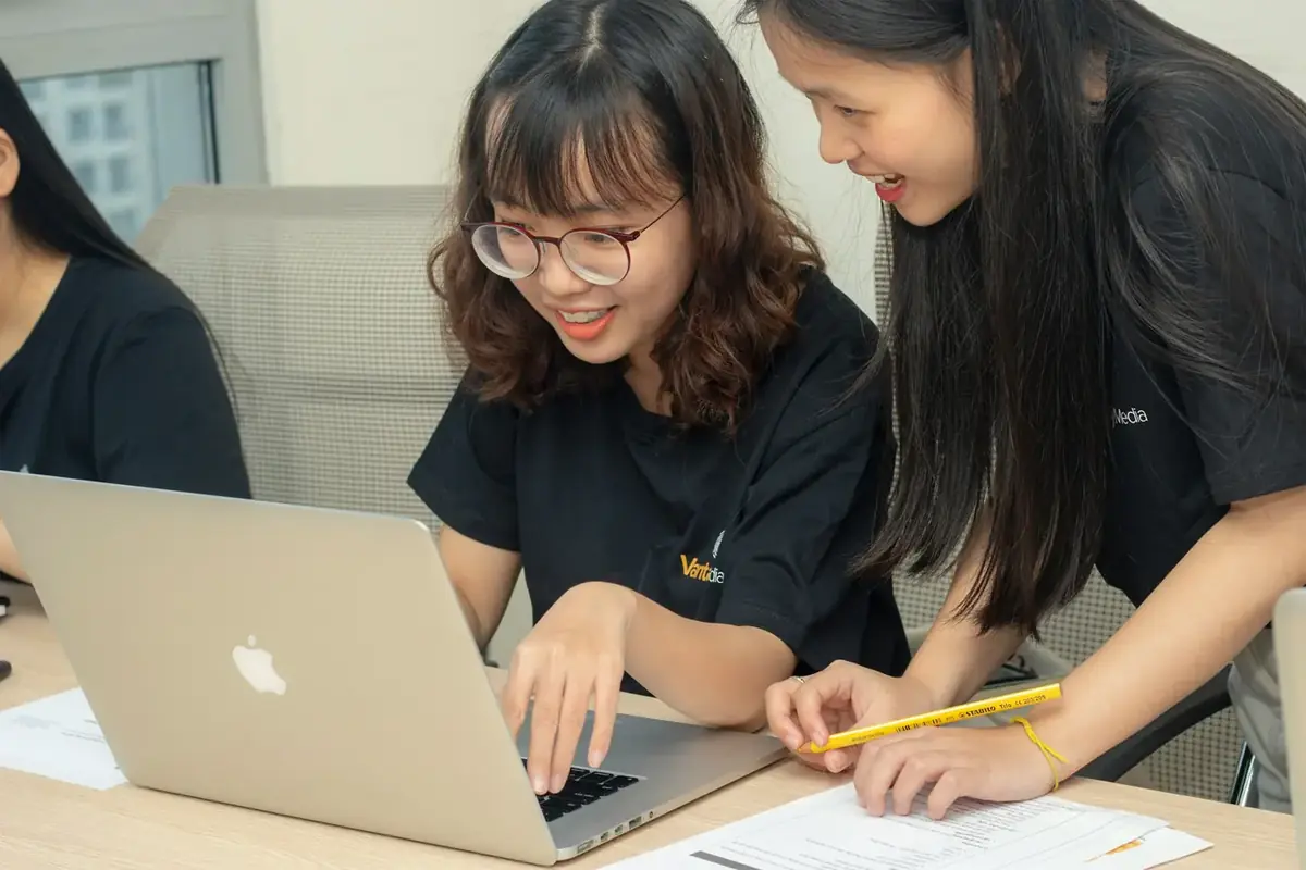 Dua murid mengerjakan materi kelas bersama di depan laptop